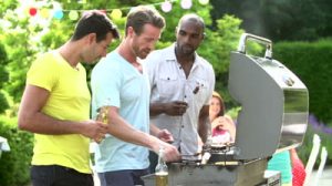 stock-footage-three-men-cooking-on-barbecue-and-toasting-beer-bottles-in-backyard